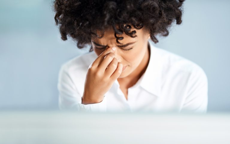Woman experiencing sinus pressure from allergies